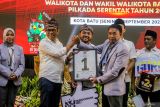 Ketua KPU Kota Batu Heru Joko Purwanto (kanan) menyerahkan plakat nomor urut kepada calon Wali Kota Batu nomor urut satu Nurochman (kiri) saat Pengundian dan Penetapan Nomor Urut Pasangan Calon Wali Kota dan Wakil Wali Kota Batu di Kota Batu, Jawa Timur, Senin (23/9/2024). KPU Kota Batu menetapkan pasangan calon Wali Kota dan Wakil Wali Kota Nurochman - Heli Suyanto dengan nomor urut satu sementara pasangan Firhando Gumelar - Rudi dengan nomor dua dan pasangan Krisdayanti - Kresna Dewanata Phrosakh nomor urut tiga. Antara Jatim/Muhammad Mada/um