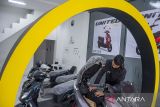 Pramuniaga memeriksa kondisi motor listrik di sebuah dealer di Ngamprah, Kabupaten Bandung Barat, Jawa Barat, Selasa (24/9/2024). Kementerian Koordinator Bidang Kemaritiman dan Investasi menargetkan penggunaan kendaraan listrik (electric vehicle/EV) dapat mencapai 13 juta kendaraan roda dua listrik (e-2W) dan 2 juta kendaraan roda empat listrik (e-4W) pada 2030. ANTARA FOTO/Abdan Syakura/agr