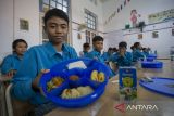 Siswa menunjukkan menu makanan bergizi gratis saat kegiatan mitigasi operasional dan uji coba makan bergizi gratis (MBG) di SMPN 1 Cirebon, Kota Cirebon, Jawa Barat, Rabu (25/9/2024). Uji coba makan bergizi gratis tersebut bertujuan untuk memberi edukasi siswa tentang pentingnya pemenuhan gizi seimbang bagi tumbuh kembang dan upaya mempersiapkan generasi emas Indonesia. ANTARA FOTO/Dedhez Anggara/agr