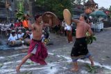 Dua warga saling memukul menggunakan daun langsat saat tradisi grudug langsat pada Hari Raya Galungan di lingkungan Langsat, Desa Rendang, Karangasem, Bali, Rabu (25/9/2024). Tradisi perang dengan bersenjata daun langsat tersebut digelar sebagai simbol kerukunan umat sekaligus perayaan kemenangan Dharma (kebaikan) melawan Adharma (kejahatan). ANTARA FOTO/Nyoman Hendra Wibowo/wsj.