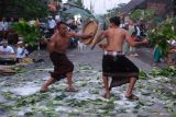 Dua warga saling memukul menggunakan daun langsat saat tradisi grudug langsat pada Hari Raya Galungan di lingkungan Langsat, Desa Rendang, Karangasem, Bali, Rabu (25/9/2024). Tradisi perang dengan bersenjata daun langsat tersebut digelar sebagai simbol kerukunan umat sekaligus perayaan kemenangan Dharma (kebaikan) melawan Adharma (kejahatan). ANTARA FOTO/Nyoman Hendra Wibowo/wsj.