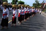 Umat Hindu menjunjung keben bambu atau tempat sesajen saat tradisi Mapeed pada rangkaian persembahyangan Hari Raya Galungan di Desa Lukluk, Badung, Bali, Rabu (25/9/2024). Ratusan perempuan Bali di desa tersebut setiap Hari Raya Galungan menggelar tradisi berjalan beriringan dengan menjunjung sesajen dan mengenakan kebaya dan kain yang seragam. ANTARA FOTO/Nyoman Hendra Wibowo/wsj.