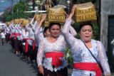 Umat Hindu menjunjung keben bambu atau tempat sesajen saat tradisi Mapeed pada rangkaian persembahyangan Hari Raya Galungan di Desa Lukluk, Badung, Bali, Rabu (25/9/2024). Ratusan perempuan Bali di desa tersebut setiap Hari Raya Galungan menggelar tradisi berjalan beriringan dengan menjunjung sesajen dan mengenakan kebaya dan kain yang seragam. ANTARA FOTO/Nyoman Hendra Wibowo/wsj.