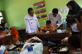 Penjabat (Pj) Bupati Jombang, Teguh Narutomo (kiri) meninjau simulasi program makan siang gratis di SDN 1 Kepatihan, Kabupaten Jombang, Jawa Timur, Rabu (25/9/2024). Pemerintah Desa Kepatihan Jombang menyediakan 350 porsi pada simulasi program makan siang gratis dengan menu makanan bergizi, nasi lauk ayam, daging, telur, sayur, air mineral, susu dan buah senilai Rp25 ribu per porsi untuk pelajar diÂ sekolah tersebut. ANTARA Jatim/Syaiful Arif/mas.