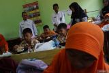 Penjabat (Pj) Bupati Jombang, Teguh Narutomo (kiri) meninjau simulasi program makan siang gratis di SDN 1 Kepatihan, Kabupaten Jombang, Jawa Timur, Rabu (25/9/2024). Pemerintah Desa Kepatihan Jombang menyediakan 350 porsi pada simulasi program makan siang gratis dengan menu makanan bergizi, nasi lauk ayam, daging, telur, sayur, air mineral, susu dan buah senilai Rp25 ribu per porsi untuk pelajar diÂ sekolah tersebut. ANTARA Jatim/Syaiful Arif/mas.