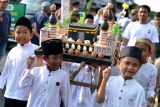 Sejumlah anak memanggul hiasan berisi telur saat Festival Telur Hias di kampung Wanasari, Denpasar, Bali, Kamis (26/9/2024). Festival tersebut diikuti ratusan warga setempat dengan menampilkan berbagai kreasi hiasan telur dan pertunjukan seni tradisi untuk memperingati Maulid Nabi Muhammad SAW. ANTARA FOTO/Fikri Yusuf/wsj.