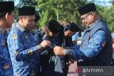 Penjabat Gubernur Aceh,  Safrizal ( kanan) menyematkan pin ASN Netral pada rompi sejumlah  Aparatur Sipil Negara (ASN) saat  apel Ikrar Netralitas ASN pemerintah Aceh pada pilkada 2024  di Banda Aceh, Aceh, Kamis (26/9/2024). Apel Ikrar Netralitas  dan dilanjutkan penandatangan fakta integritas di daerah itu mengatur tentang prinsip netralitas ASN sebagai pelayanan publik, menghindari konflik kepentingan, penggunaan media sosial yang bijak dan menolak politik uang pada pilkada tahun 2024. ANTARA FOTO/Ampelsa.