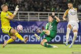 Pesepak bola Persebaya Surabaya Slavko Damjanovic (tengah) menendang bola bola dengan dihadang kiper Dewa United Sonny Stevens (kiri) pada pertandingan BRI Liga 1 di Stadion Gelora Bung Tomo, Surabaya, Jawa Timur, Jumat (27/9/2024). Pertandingan berakhir imbang dengan skor 0-0. ANTARA Jatim/Rizal Hanafi/mas.