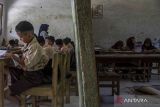 Sejumlah siswa mengikuti kegiatan belajar mengajar di ruang kelas SD Negeri Cijakan 3, Kabupaten Pandeglang, Banten, Jumat (27/9/2024). Sekolah tersebut mengalami kerusakan karena terdampak proyek pembangunan Tol Serang-Panimbang seksi III Cileles-Panimbang, dan hingga kini belum ada upaya perbaikan yang berarti dari pihak terkait ataupun relokasi untuk kegiatan belajar mengajar. ANTARA FOTO/Angga Budhiyanto/gp