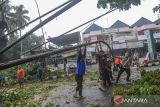 Personel kepolisian dibantu warga memindahkan tiang lampu yang tumbang diterjang angin kencang di Jalan Hardiwinangun Rangkasbitung, Lebak, Banten, Sabtu (28/9/2024). BPBD Kabupaten Lebak mencatat bencana angin kencang yang merobohkan tujuh pohon di kawasan Rangkasbitung tersebut menyebabkan lima unit rumah rusak, dua perkantoran rusak, puluhan makam rusak, aliran listrik dan jaringan internet terputus. ANTARA FOTO/Muhammad Bagus khoirunas/gp