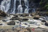 Pengunjung berfoto dengan latar belakang Curug Malela di Rongga, Kabupaten Bandung Barat, Jawa Barat, Sabtu (28/9/2024). Pemerintah menargetkan nilai devisa pariwisata pada 2025 sebesar 22,10 miliar dolar AS atau setara Rp342 triliun yaitu meningkat dibanding capaian pada 2023 sebesar 14,63 miliar dolar AS dan lebih tinggi dari outlook 2024 sebesar 17,54 miliar dolar AS. ANTARA FOTO/Abdan Syakura/agr
