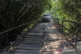 Pengendara melintasi jembatan Kijama di Carengan, Kabupaten Serang, Banten, Selasa (1/10/2024). Akses jembatan yang berada diatas sungai Cidurian menjadi penghubung antara Kabupaten Serang dan Kabupaten Tangerang tersebut kondisinya rusak selama puluhan tahun dengan sebagian kayu terlepas dan hingga kini belum diperbaiki.  ANTARA FOTO/Muhammad Bagus Khoirunas/gp