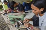 Perajin menyelesaikan pembuatan angklung mini di Kampung Angklung, Desa Panyingkiran, Kabupaten Ciamis, Jawa Barat, Selasa (1/10/2024). Kelompok Pemuda Panji Ampel memanfaatkan limbah ranting bambu untuk dijadikan berbagai macam cendera mata angklung diantaranya berupa gantungan kunci, pin, dan miniatur angklung dengan harga Rp10 ribu hingga Rp150 ribu per buah yang dipasarkan melalui platfrom digital. ANTARA FOTO/Adeng Bustomi/agr