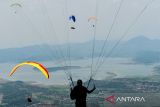 Peserta kategori Cross Country mengudara di atas Waduk Jatigede saat mengikuti West Java Paragliding Championship di Batu Dua, Kabupaten Sumedang, Jawa Barat, Selasa, (1/10/2024). Kejuaraan Intenasional Paralayang yang diikuti 99 peserta dari 10 negara di Eropa dan Asia tersebut digelar sebagai ajang untuk mengasah bakat potensial agar dapat bersaing pada kompetisi internasional serta menjadi salah satu langkah untuk mendongkrak potensi wisatawan yang berkunjung ke Kabupaten Sumedang. ANTARA FOTO/Raisan Al Farisi/agr