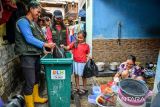 Petugas mengambil sampah organik milik warga di Lio Genteng, Nyengseret, Bandung, Jawa Barat, Rabu (2/10/2024). Kelurahan Nyengseret Kecamatan Astanaanyar melakukan inovasi layanan Sidak Panik (Simpen, candak, jemput sampah organik) yang merupakan layanan jemput bola sampah organik bagi masyarakat di permukiman padat yang tidak memiliki lahan untuk menyimpan sampah guna mengurangi produksi sampah organik di Kota Bandung. ANTARA FOTO/Raisan Al Farisi/agr
