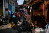 Petugas berjalan menyusuri permukiman padat untuk mengambil sampah organik di Lio Genteng, Nyengseret, Bandung, Jawa Barat, Rabu (2/10/2024). Kelurahan Nyengseret Kecamatan Astanaanyar melakukan inovasi layanan Sidak Panik (Simpen, candak, jemput sampah organik) yang merupakan layanan jemput bola sampah organik bagi masyarakat di permukiman padat yang tidak memiliki lahan untuk menyimpan sampah guna mengurangi produksi sampah organik di Kota Bandung. ANTARA FOTO/Raisan Al Farisi/agr
