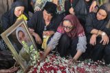 Penyanyi Ikang Fawzi (kedua kiri) bersama putrinya Bella Fawzi (kiri) dan Chikita Fawzi (kedua kanan) duduk di dekat makam Marissa Haque di TPU Tanah Kusir, Jakarta, Rabu (2/10/2024). Aktris dan politikus Marissa Haque meninggal dunia pada usia 62 tahun. ANTARA FOTO/Muhammad Iqbal/rwa/gp