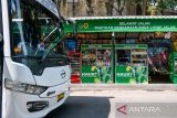 Bus melintas di depan kios pemberdayaan pedagang kaki lima di Terminal Leuwipanjang, Bandung, Jawa Barat, Kamis (3/10/2024). Kementerian Perhubungan dan Koperasi Konsumen Sabilulungan Balai Pengelola Transportasi Darat Jawa Barat memberdayakan pelaku UKM dan pedagang kaki lima yang ada di sekitar Terminal Leuwipanjang dengan menyediakan gerai untuk menjual produknya guna meningkatkan perekonomian masyarakat. ANTARA FOTO/Raisan Al Farisi/agr