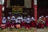 Siswa membaca buku di depan ruang kelas yang disegel di SDN Senangsari, Kecamatan Pagelaran, Pandeglang, Banten, Kamis (3/10/2024). Menurut penuturan pihak sekolah ruang kelas baru (RKB) yang diperuntukkan bagi siswa kelas enam tersebut telah disegel oleh pihak yang mengaku ahli waris, sehingga kegiatan belajar mengajar terpaksa dilakukan di teras kelas atau dipindahkan ke ruang kelas lain yang tersedia. ANTARA FOTO/Angga Budhiyanto/gp