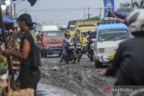 Pengendara roda dua menghindari jalan rusak di Pasar Induk Rau, Kota Serang, Banten, Jumat (4/10/2024). Akses jalan utama menuju kawasan Pasar Induk Rau tersebut rusak dan berlubang hingga kini belum diperbaiki oleh Pemkot Serang sehingga rawan mengakibatkan kecelakaan lalu lintas. ANTARA FOTO/Muhammad Bagus Khoirunas/gp