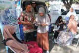 Petugas Badan Penyelenggara Jaminan Sosial (BPJS) Kesehatan (kedua kiri) melayani mahasiswa saat pengurusan kepesertaan Jaminan Kesehatan Nasional (JKN) menggunakan aplikasi mobile di Universitas Muhammadiyah, Banda Aceh, Aceh, Jumat (4/10/2024). BPJS Kesehatan mencatat jumlah peserta JKN hingga 1 Agustus 2024 telah mencapai 276.520.647 jiwa atau 98,19 persen, sesuai dengan target Rencana Pembangunan Jangka Menengah Nasional (RPJMN) tahun 2020-2024 kepesertaan JKN sebesar 98 persen, sehingga atas capaian ini Indonesia meraih predikat Universal Health Coverage (UHC) 2024. ANTARA FOTO/Khalis Surry