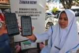 Mahasiswa memperlihatkan akun Jaminan Kesehatan Nasional (JKN) dari aplikasi mobile saat layanan jemput bola pengurusan kepesertaan dari Badan Penyelenggara Jaminan Sosial (BPJS) Kesehatan di Universitas Muhammadiyah, Banda Aceh, Aceh, Jumat (4/10/2024). BPJS Kesehatan mencatat jumlah peserta JKN hingga 1 Agustus 2024 telah mencapai 276.520.647 jiwa atau 98,19 persen, sesuai dengan target Rencana Pembangunan Jangka Menengah Nasional (RPJMN) tahun 2020-2024 kepesertaan JKN sebesar 98 persen, sehingga atas capaian ini Indonesia meraih predikat Universal Health Coverage (UHC) 2024. ANTARA FOTO/Khalis Surry