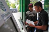 Petugas Badan Penyelenggara Jaminan Sosial (BPJS) Kesehatan (kanan) melayani warga untuk pengecekan kepesertaan Jaminan Kesehatan Nasional (JKN) menggunakan secara digital di Kantor BPJS Kesehatan Cabang Banda Aceh, Aceh, Jumat (4/10/2024). BPJS Kesehatan mencatat jumlah peserta JKN hingga 1 Agustus 2024 telah mencapai 276.520.647 jiwa atau 98,19 persen, sesuai dengan target Rencana Pembangunan Jangka Menengah Nasional (RPJMN) tahun 2020-2024 kepesertaan JKN sebesar 98 persen, sehingga atas capaian ini Indonesia meraih predikat Universal Health Coverage (UHC) 2024. ANTARA FOTO/Khalis Surry