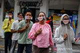 Peserta aksi membawa topeng orang tersenyum saat melakukan aksi di Jalan Braga, Bandung, Jawa Barat, Jumat (4/10/2024). Pegawai Kantor LKBN Antara Biro Jawa Barat bersama mahasiswa Unpad, Upi, dan UIN Sunan Gunung Djati menggelar aksi membagikan topeng tersenyum yang dilaksanakan dalam rangka memperingati Hari Senyum Sedunia. ANTARA FOTO/Raisan Al Farisi/agr