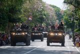 Sejumlah warga menaiki kendaraan tempur saat parade Alutsista pada peringatan Hari Ulang Tahun (HUT) ke-79 Tentara Nasional Indonesia (TNI) di Lapangan Puputan Margarana Niti Mandala, Denpasar, Bali, Sabtu (5/10/2024). Kodam IX/Udayana melaksanakan berbagai kegiatan dalam rangka memperingati HUT ke-79 TNI yakni upacara parade, demonstrasi bela diri, demonstrasi penanggulangan teror, serta defile pasukan dan Alutsista dengan mengusung tema TNI Modern Bersama Rakyat Siap Mengawal Suksesi Kepemimpinan Nasional Untuk Indonesia Maju. ANTARA FOTO/Nyoman Hendra Wibowo/wsj.