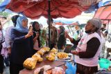 Calon Gubernur Jawa Timur nomor urut dua Khofifah Indar Parawansa (kiri) berbincang dengan pedagang buah nangka saat berkampanye di Pasar Wonokromo, Surabaya, Jawa Timur, Sabtu (5/10/2024). Dalam kampanye tersebut Khofifah berdialog untuk menyerap aspirasi pedagang sekaligus membeli barang dagangan mereka. ANTARA Jatim/Moch Asim.