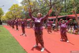 Sejumlah peserta menari Sanduk berlatar belakang bunga Tabebuya saat mengikuti lomba tari Sanduk di Jalan Ksatrian Pusdik Arhanud, Batu, Jawa Timur, Sabtu (5/10/2024). Agenda yang diikuti ratusan peserta itu diinisiasi pemerintah setempat bersama Pusat Pendidikan Artileri Pertahanan Udara (Pusdik Arhanud) sebagai upaya mempromosikan pariwisata Kota Batu dan memeriahkan perayaan Hari Ulang Tahun (HUT) ke-79 TNI. Antara Jatim/Muhammad Mada/um 