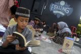 Sejumlah anak membaca buku di area taman Kampung Pekijing, Kota Serang, Banten, Minggu (6/10/2024). Warga setempat menjadikan kawasan Kampung Pekijing menjadi kampung wisata literasi sebagai pusat kampanye literasi dengan menyediakan titik peminjaman buku di setiap rumah dan taman. ANTARA FOTO/Muhammad Bagus Khoirunas/gp