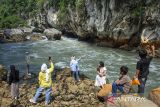 Wisatawan berfoto di kawasan Geo Wisata Sanghyang Kenit, Kampung Cisameng, Rajamandala Kulon, Kabupaten Bandung Barat, Jawa Barat, Minggu (6/10/2024). Geo Wisata Sanghyang Kenit yang termasuk bagian dari aliran Sungai Citarum purba tersebut menjadi salah satu destinasi favorit wisata di akhir pekan dengan menawarkan panorama gua karst, sungai serta bebatuan purba. ANTARA FOTO/Abdan Syakura/agr