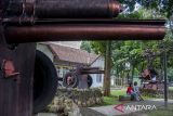 Warga duduk di depan meriam di Taman Meriam, Kota Cimahi, Jawa Barat, Minggu (6/10/2024). Pemerintah Daerah Kota Cimahi menginisiasi program Cimahi Military Heritage Tourism yang bertujuan untuk mendorong pariwisata Kota Cimahi melalui konsep eduwisata pengenalan sejarah militer dan bangunan-bangunan bersejarah. ANTARA FOTO/Abdan Syakura/agr