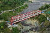 Foto udara sejumlah kendaraan melintasi Jembatan Besuk Koboa'an di Lumajang, Jawa Timur, Senin (7/10/2024). Direktorat Jenderal Bina Marga di bawah Kementerian PUPR Indonesia meraih penghargaan rekor MURI dalam pembangunan Jembatan Besuk Koboa'an sebagai Jembatan Pratt Truss terpanjang di Indonesia dengan panjang bentang mencapai 140 meter. Antara Jatim/Irfan Sumanjaya/um