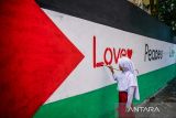 Siswi SDN Astanaanyar 249 melukis di tembok di kawasan permukiman Liogenteng, Bandung, Jawa Barat, Senin (7/10/2024). Solidaritas seni untuk Palestina bersama warga Liogenteng menggelar aksi bela Palestina dengan melukis tembok rumah di permukiman padat dalam rangka memperingati satu tahun agresi Israel ke Palestina. ANTARA FOTO/Raisan Al Farisi/agr