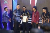 Menteri Agraria dan Tata Ruang/Kepala Badan Pertanahan Nasional (ATR/BPN) Agus Harimurti Yudhoyono (kedua kiri) didampingi Pj Gubernur Jawa Timur Adhy Karyono (kiri) menyerahkan sertipikat hak milik atas tanah kepada warga saat Deklarasi 46 Kota/Kabupaten Lengkap di 23 Provinsi serta Implementasi dan Penyerahan Sertipikat Elektronik di Gedung Negara Grahadi, Surabaya, Jawa Timur, Selasa (8/10/2024). Kegiatan deklarasi tersebut menandai langkah maju dalam pengurusan tanah dan pemetaan yang lebih efektif guna memberi kepastian hukum hak atas tanah bagi masyarakat, investor serta meminimalisir sengketa dan konflik pertanahan. ANTARA Jatim/Moch Asim.