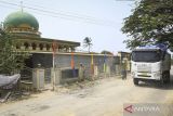 \Truk tambang melintas di depan Masjid Jami Al Hikmah, Desa Bakung, Kronjo, Kabupaten Tangerang, Banten, Rabu (9/10/2024). Pengelola mengaku harus menutupi masjid dengan terpal untuk mengurangi masuknya kotoran debu dari truk tambang tanah yang melintas  tidak sesuai jam operasional di Jalan Raya Kronjo dan harus berkali-kali menyapu lantai guna menjaga kenyamanan beribadah. ANTARA FOTO/Sulthony Hasanuddin/aww/gp