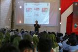 Komisioner KPU Banyuwangi Enot Sugiharto menunjukan foto calon Gubernur dan wakil Gubernur Jawa Timur pada sosialisasi demokrasi bagi pemilih pemula di Aula SMK Negeri 1 Banyuwangi, Jawa Timur, Rabu (9/10/2024). Kegiatan tersebut sebagai upaya KPU untuk peningkatan partisipasi pemilih terutama dikalangan pemilih muda dan pemula agar tersalurkan dengan baik pada pemilu mendatang. ANTARA Jatim/Budi Candra Setya/mas.