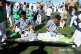 Anggota Usaha Kesehatan Sekolah (UKS) mengobat rekannya yang mengalami luka ringan di lantai bertingkat gedung penyelamatan Museum Tsunami Aceh saat berlangsung Simulasi Evakuasi Mandiri di Banda Aceh, Aceh, Rabu (9/10/2024). Simulasi Evakuasi Mandiri yang diawali di sekolah dan kemudian dilanjutkan evakuasi masal pelajar ke gedung penyelamatan Museum Tsunami Aceh itu dalam rangkaian Peringatan Bulan Pengurangan Resiko Bencana (PRB) dengan melibatkan sebanyak 3.565 pelajar SD, SMP dan SMA yang bertujuan meningkatkan kesiapsiagaan dan mengurangi resiko korban jika terjadi bencana. ANTARA FOTO/Ampelsa.