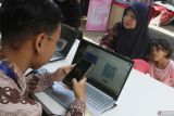 Petugas Dinas Kependudukan dan Pencatatan Sipil (Disdukcapil) membantu warga membuat Kartu Identitas Anak (KIA)  dalam pelayanan administrasi kependudukan jemput bola di Kantor Kelurahan Sukun, Malang, Jawa Timur, Kamis (10/10/2024). Kegiatan tersebut dilakukan di sejumlah titik sebagai salah satu upaya mendukung percepatan capaian target perekaman KTP elektronik  penduduk di Indonesia berusia 17 tahun ke atas sebesar 99,4 persen atau sebanyak 207.889.876 jiwa. ANTARA Jatim/Ari Bowo Sucipto/mas.