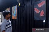 Pengunjung melihat lukisan di Taman Budaya, Pontianak, Kalimantan Barat, Kamis (10/10/2024). Dalam pameran tersebut menampilkan 50 karya seni rupa hasil karya lima pelukis Kalbar dan anak-anak yang telah mengikuti kegiatan melukis  yang digelar UPT Museum Kalbar. Antara Kalbar/Edo Saputra/Jhw