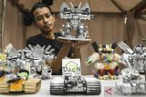 Pengrajin menunjukkan miniatur robot berbahan limbah di Tigaraksa, Kabupaten Tangerang, Banten, Jumat (11/10/2024). Pengrajin Yayasan Oemah Daon memanfaatkan limbah rumah tangga seperti botol kemasan bekas hingga mainan bekas untuk dijadikan miniatur robot yang dijual seharga Rp50 ribu hingga Rp500 ribu tergantung ukuran, sekaligus sebagai sarana edukasi pemanfaatan limbah menjadi karya kepada masyarakat. ANTARA FOTO/Sulthony Hasanuddin/gp