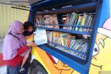 Warga membaca buku koleksi mobil perpustakaan keliling secara gratis di Jl Doho, Kota Kediri, Jawa Timur, Minggu (13/10/2024). Pemerintah Kota Kediri mengoperasikan sejumlah mobil perpustakaan keliling di berbagai titik keramaian guna menyediakan bahan bacaan bermutu sebagai upaya mendorong minat baca masyarakat. Antara Jatim/Prasetia Fauzani/um