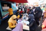 Petugas Dinas Kependudukan dan Pencatatan Sipil melakukan layanan kependudukan kepada warga di Kota Kediri, Jawa Timur, Minggu (13/10/2024). Pemerintah daerah setempat mengoperasikan mobil layanan keliling ke sejumlah tempat keramaian guna membantu warga mendapatkan layanan kependudukan diantaranya aktivasi Identitas Kependudukan Digital (IKD) sebagai upaya mempercepat transformasi KTP Digital. Antara Jatim/Prasetia Fauzani/um