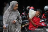 Warga penerima manfaat memikul  karung berisi beras  10 kilogram saat penyaluran di Kantor PT Pos Indonesia (Persero) Banda Aceh, Aceh, Sabtu (12/10/2024). Pemerintah kembali menyalurkan bantuan pangan beras sebanyak 10 kilogram tahap ketiga tahun 2024 periode Agustus, Oktober dan Desember 2024 kepada sebanyak  22 juta keluarga penerima manfaat (KPM) di seluruh Indonesia dalam upaya membantu meringankan beban ekonomi masyarakat dan pengendalian inflasi. ANTARA FOTO/Ampelsa