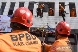 Anggota BPBD Ciamis mengevakuasi korban dengan cara vertical rescue saat simulasi penanganan bencana alam megathrust dan hidrometeorologi basah di kantor Setda Kabupaten Ciamis, Jawa Barat, Kamis (17/10/2024). Simulasi mitigasi bencana tersebut untuk memberikan edukasi, sosialisasi, dan kesiapsiagaan di lingkungan pegawai negeri sipil dalam penanggulangan serta pengurangan resiko bencana megathrust. ANTARA FOTO/Adeng Bustomi/agr
