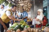 Calon Gubernur Kalimantan Timur nomor urut 2 Rudy Mas'ud (kiri) membeli buah pisang saat blusukan di Pasar Kedondong, Samarinda, Kaltim, Minggu (20/10/2024). Kunjungan dari Rudy Mas'ud yang berpasangan dengan calon Wakil Gubernur Seno Aji tersebut bertujuan untuk menyerap aspirasi dari pedagang hingga berjanji akan menjaga stabilitas harga bahan pokok. Calon Gubernur Kalimantan Timur Isran Noor (kanan) mengenakan rompi saat Silaturahmi Dayak bersama Isran-Hadi di Samarinda, Kaltim, Sabtu (19/10/2024). Dalam kampanyenya di dapan masyarakat Dayak Kaltim itu, Isran Noor-Hadi Mulyadi menyampaikan program-program unggulan yang akan kembali dilanjutkan di periode selanjutnya. Antara Kaltim/M Risyal Hidayat