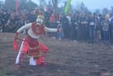 Seorang peserta menampilkan kesenian tradisi Topeng Konah saat prosesi Rokat Bhumi (meruwat bumi) dalam rangkaian Ijen Caldera Fiesta di Kawah Wurung, Bondowoso, Jawa Timur, Sabtu (19/10/2024). Tradisi tersebut digelar sebagai tolak bala, memohon hasil bumi melimpah dan agar dijauhkan dari bahaya. Antara Jatim/Seno/mas.