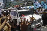 Presiden Prabowo Subianto berdiri menyapa warga dari mobil Pindad Maung Garuda di Jalan MH. Thamrin, Jakarta, Minggu (20/10/2024). Prabowo Subianto dan Gibran Rakabuming Raka menjadi Presiden dan Wakil Presiden Republik Indonesia masa bakti 2024-2029 setelah dilantik di MPR.ANTARA FOTO/Zaky Fahreziansyah/app/YU/gp